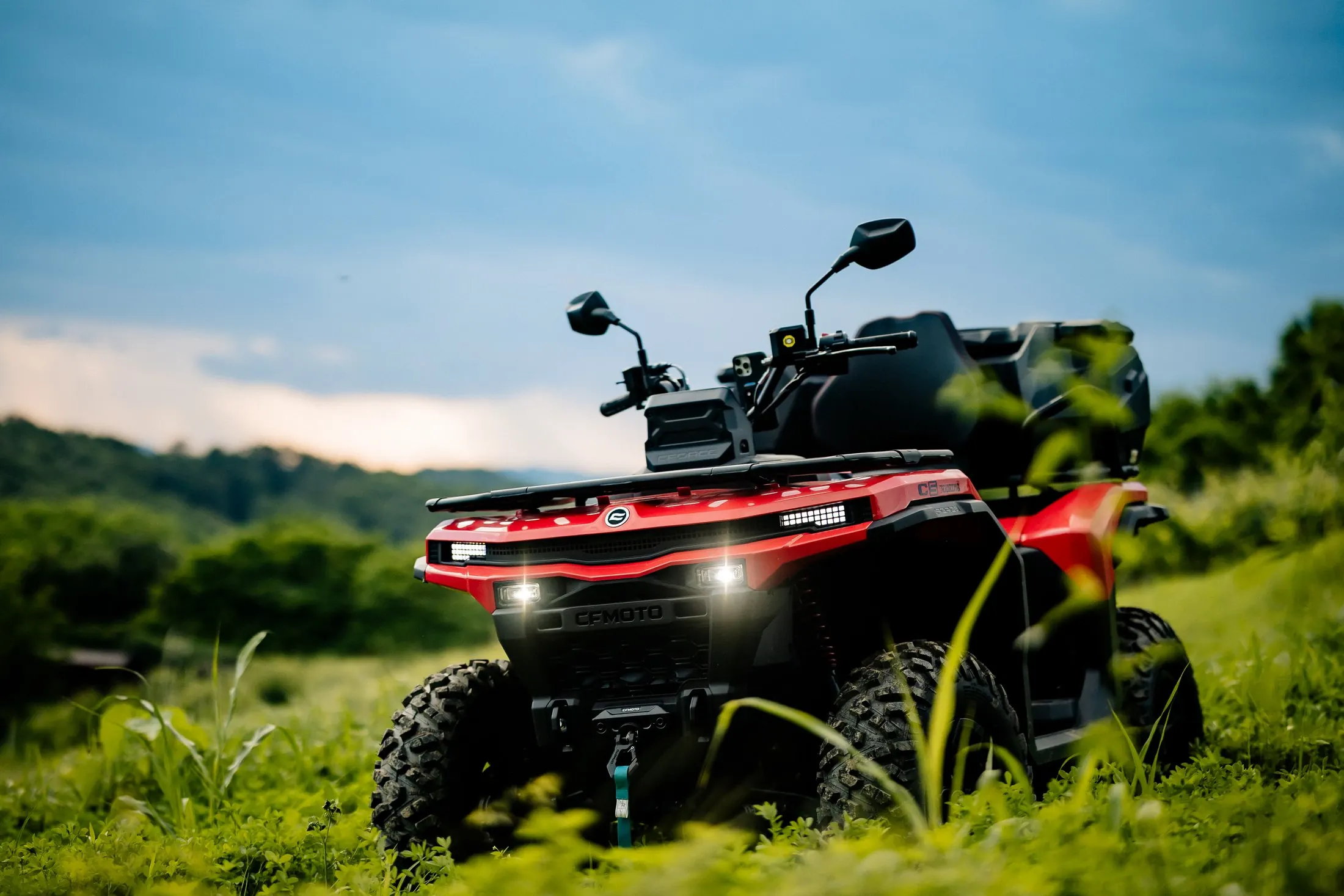 Crveni quad u travi s pogledom na nebo i bregove